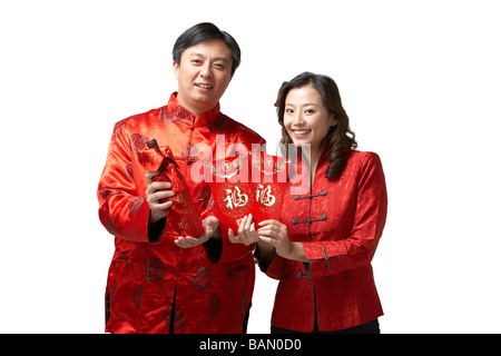 Un couple est titulaire des cadeaux et une bouteille de vin pour le Nouvel An chinois Banque D'Images