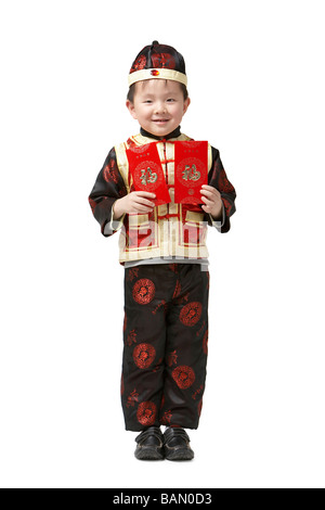 Un jeune garçon est titulaire d'une des enveloppes rouges pour le Nouvel An chinois Banque D'Images