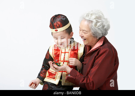 Une grand-mère partage candy avec son petit-fils sur le Nouvel An chinois Banque D'Images