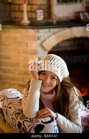 Young woman smiling devant une cheminée Banque D'Images