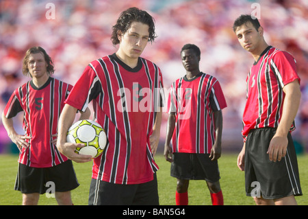 Joueurs de football posant pour l'appareil photo de pitch Banque D'Images