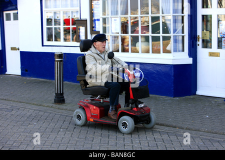 Hauts homme monté sur son scooter de mobilité Banque D'Images