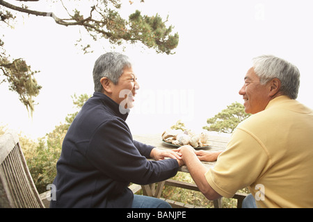 Senior Asian couple parler et rire à l'extérieur Banque D'Images