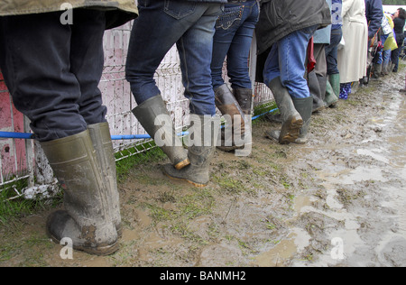 Une ligne de couleur divers wellies (bottes) en conditions boueuses. Banque D'Images