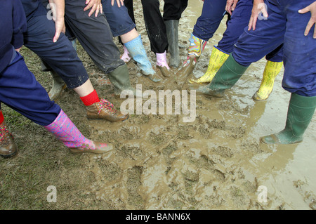 Une ligne de couleur divers wellies (bottes) en conditions boueuses. Banque D'Images