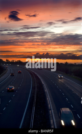 La circulation routière sur l'autoroute M5 au coucher du soleil, près de Dursley, Gloucestershire. Banque D'Images