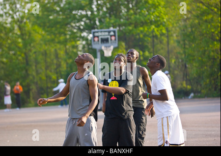 Dimanche après-midi. Les joueurs de basket-ball watch occasionnels avec joie et impatience, comme leur basket-ball propitiously vacille sur le bord ! Banque D'Images