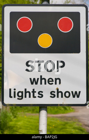 La gare ferroviaire d'arrêt du passage à niveau quand les feux de signalisation routière montrer roadsign Uk Banque D'Images