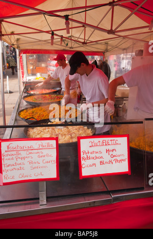 Les aliments chauds, notamment de la paella et la tartiflette en vente sur un étal du marché français à Norwich, Norfolk, UK Banque D'Images