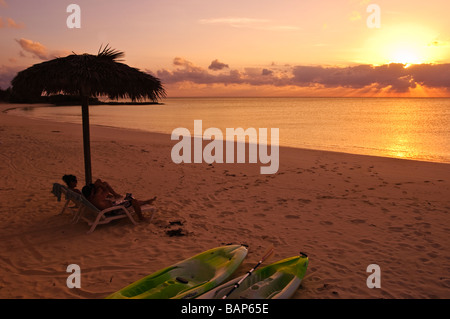 Couple sous parapluie sur beach Cat Island, Bahamas. Banque D'Images