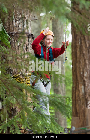 Une femme travaille son chemin à travers un parcours au Strathcona Park Lodge, BC Banque D'Images