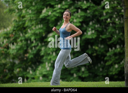 Young woman running jogging ou garder l'ajustement dans un parc Banque D'Images