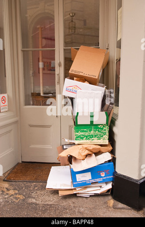 Boîtes de carton déchets empilés à l'extérieur de la porte d'une boutique Banque D'Images