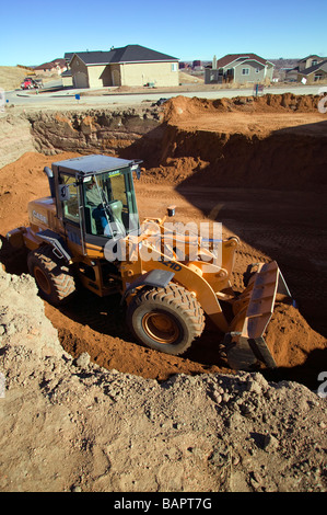 Chargeur avant l'excavation de sous-sol pour les logements neufs Banque D'Images