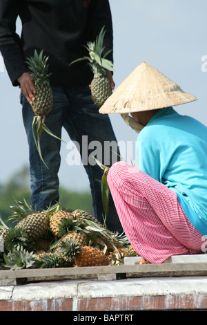 Un ananas vendeur vend des fruits au marché flottant dans le Delta du Mekong, Vietnam Banque D'Images