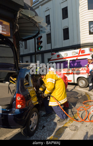 Le personnel de la Croix-Rouge sur les lieux d'un accident de voiture à Puebla, au Mexique, à l'aide de mâchoires de vie 'hurst' pour ouvrir les voiture pour déposer victi Banque D'Images