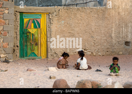 Enfants jouant dans le sable devant leur maison sur l'île de Socotra Yémen Banque D'Images