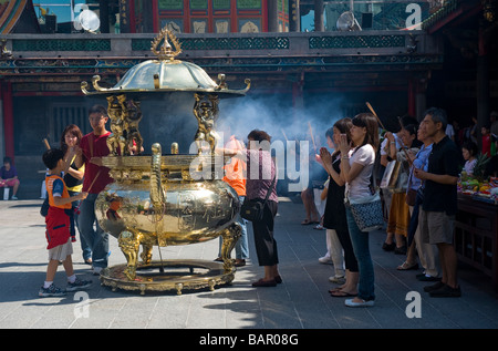 Les fidèles Bouddhistes et Taoïstes d'encens brûlant comme un rituel offrant au Mengjia Temple Lungshan. Taipei, Taiwan. Banque D'Images