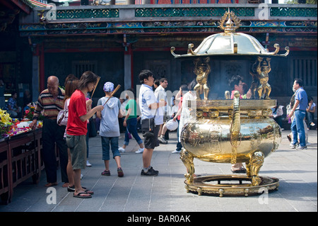 Les fidèles Bouddhistes et Taoïstes d'encens brûlant comme un rituel offrant au Temple Lungshan. Taipei, Taiwan. Banque D'Images