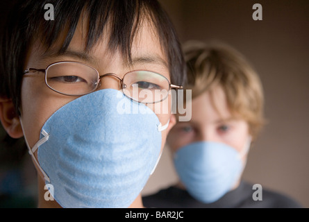 Libre de deux enfants âgés de 12 et 10 portant des masques Banque D'Images