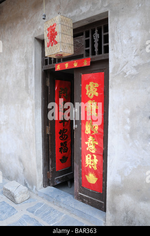 Ruelle de village ancienne Sanhe, Anhui Province, China. Les portes ont une bonne chance de bannières sur rouge pour Chinse Nouvelle Année. Banque D'Images