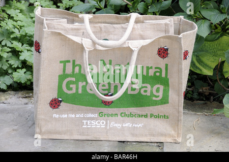 Le sac réutilisable sac vert naturel de Tesco dans jardin avec plantes derrière Banque D'Images