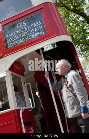 Homme habillé comme conducteur de bus à plate-forme ouverte de style traditionnel bus à impériale de Londres, vintage rallye de véhicules commerciaux. Banque D'Images