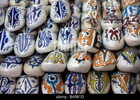 Pot en céramique décoration/Chaussons marocains (babouches) à vendre à une usine de céramique dans la médina, Fès el-Bali, Fes, Maroc Banque D'Images