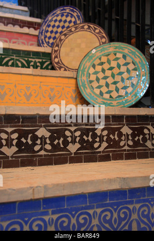 Exposés à la vente des plaques sur sol carrelé escaliers dans "l'Art Naji' usine de céramique boutique dans la médina, Fès el-Bali, au Maroc. Banque D'Images