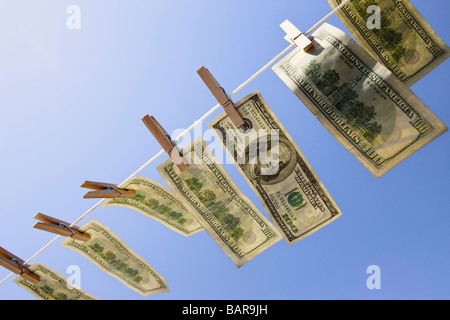 Blanchiment de capitaux - Dollars : 100 $ dollar bills le séchage dans le vent sous un ciel bleu profond. Banque D'Images