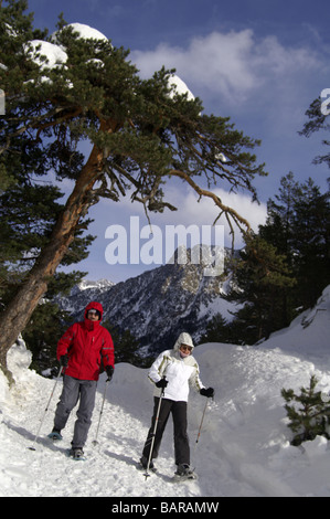 Deux randonneurs en raquettes en descendant une pente dans les Pyrénées françaises. Banque D'Images