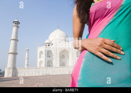 Mid section Vue d'une femme en face d'un mausolée, le Taj Mahal, Agra, Uttar Pradesh, Inde Banque D'Images