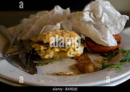 Une oeuvre inachevée et bacon et egg roll avec tomate et oignon caramélisé. Banque D'Images
