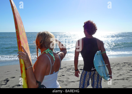 Les surfeurs surfer près de deux personnes à la droite après la vague MR Banque D'Images