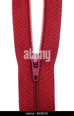 Gros plan d'une fermeture éclair rouge sur un fond blanc. Banque D'Images