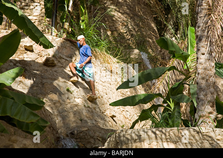 Wakir omanais est grimpant sur les jardins en terrasses d'ouvrir les canaux d'eau de l'ancien système d'irrigation Banque D'Images