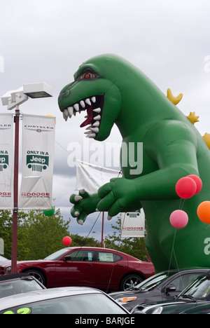 D'énormes dinosaures gonflé entre les véhicules à l'entrée d'un concessionnaire Chrysler, Jeep, Dodge concessionnaire automobile à San Jose, CA Banque D'Images