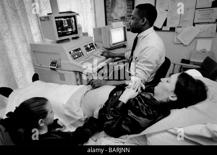 Une femme a une numérisation ultra-sons de son bébé dans la clinique de l'Homerton antinatal Hispital, Londres avec sa fille . Banque D'Images