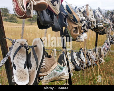 Formateurs perdus et abandonnés, des tongs et des chaussures accrochées sur barbelés Tasmanie Australie Banque D'Images