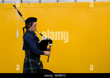 Les jeunes pratiquant PIPER POUR L'EXÉCUTION BACKSTAGE SUR LE FOND JAUNE LUMINEUX DE CAMION DE LIVRAISON Banque D'Images