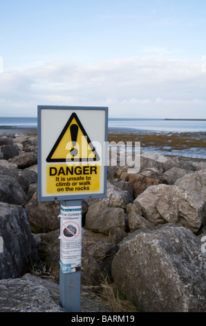 Le signe de danger Mise en garde contre l'escalade de rochers de défense de la mer Banque D'Images