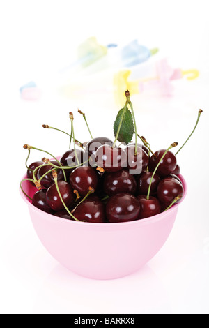 Les cerises dans un bol en plastique Banque D'Images
