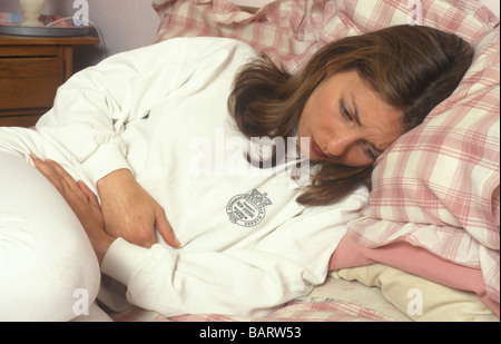 Femme doublé avec douleur abdominale Banque D'Images