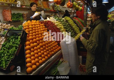 Vendeur regroupe jusqu'à un citron frais son stand de fruits et légumes dans le marché de la Boqueria à Barcelone, Espagne Banque D'Images