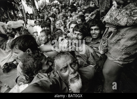 Madaripur, Bangladesh inondations : Les gens luttent dans l'écraser pour obtenir de l'aide alimentaire distribuée par l'intermédiaire de soins une ONG locale. Banque D'Images