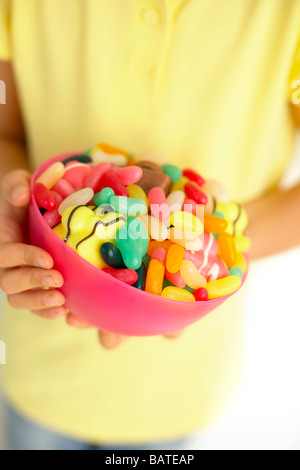 Bol de bonbons dans les mains d'un enfant. Banque D'Images