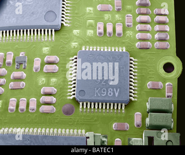 Carte circuit Microchip, scanningelectron colorées Microphotographie (SEM). La puce (bleu,square) est au centre. Banque D'Images