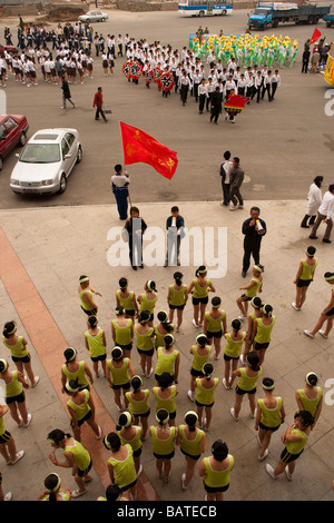 Les enfants de l'école d'arriver au stade de la ville de répéter pour un défilé devant les chefs de parti Changchun Banque D'Images