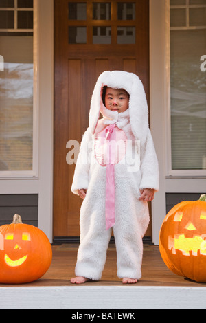 Jeune fille chinoise en costume de lapin avec des citrouilles d'Halloween Banque D'Images