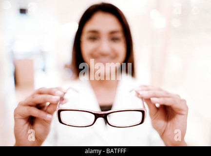 Le choix d'une paire de lunettes. Opticien aider un client à choisir une paire de lunettes. Banque D'Images